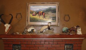 Taxidermied ferret on mantle of fireplace