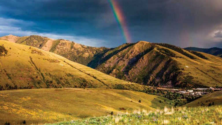 Rainbow over grassy hills