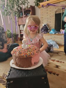 A young girl with a birthday cake and a number three candle. 