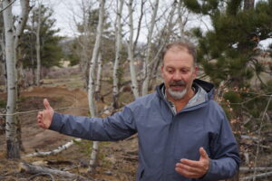 Todd Thibodeau discusses the complexities of trail design April 27, 2023 near a popular Curt Gowdy State Park trail, where crews used hundreds of pounds of rocks, among other materials, to connect features for a flowing system. (Katie Klingsporn/WyoFile)